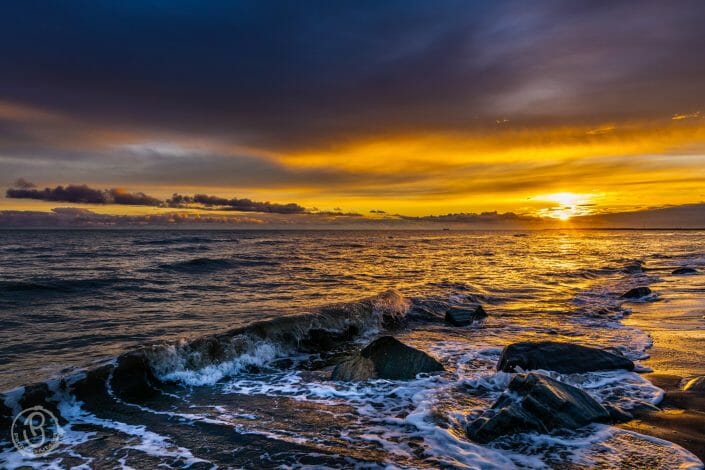 Sun setting over incoming tide