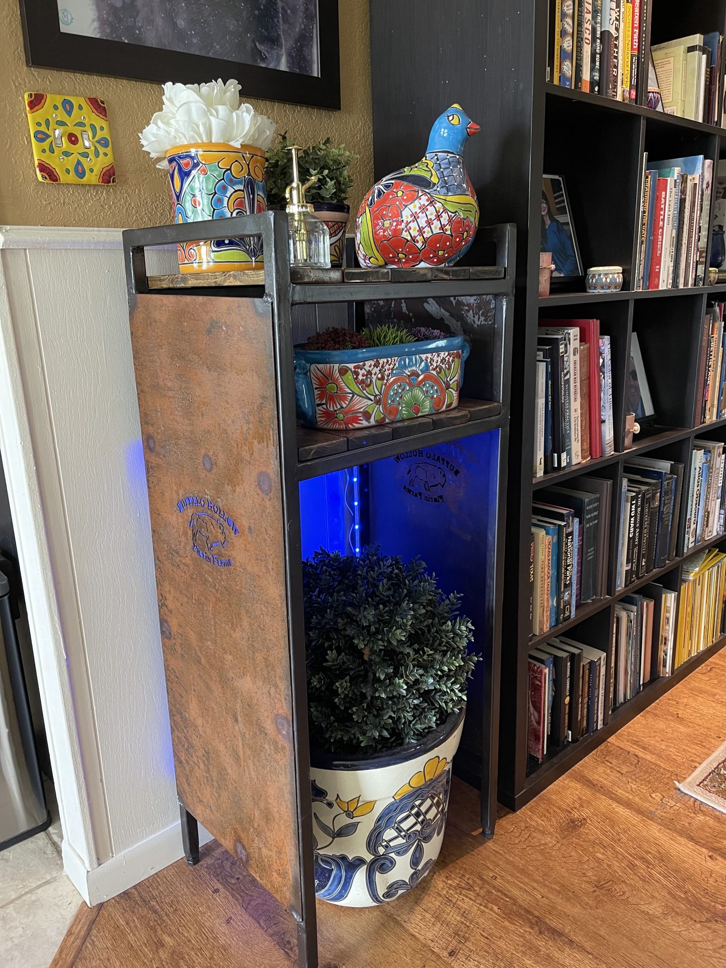 Metal plant stand in room with books